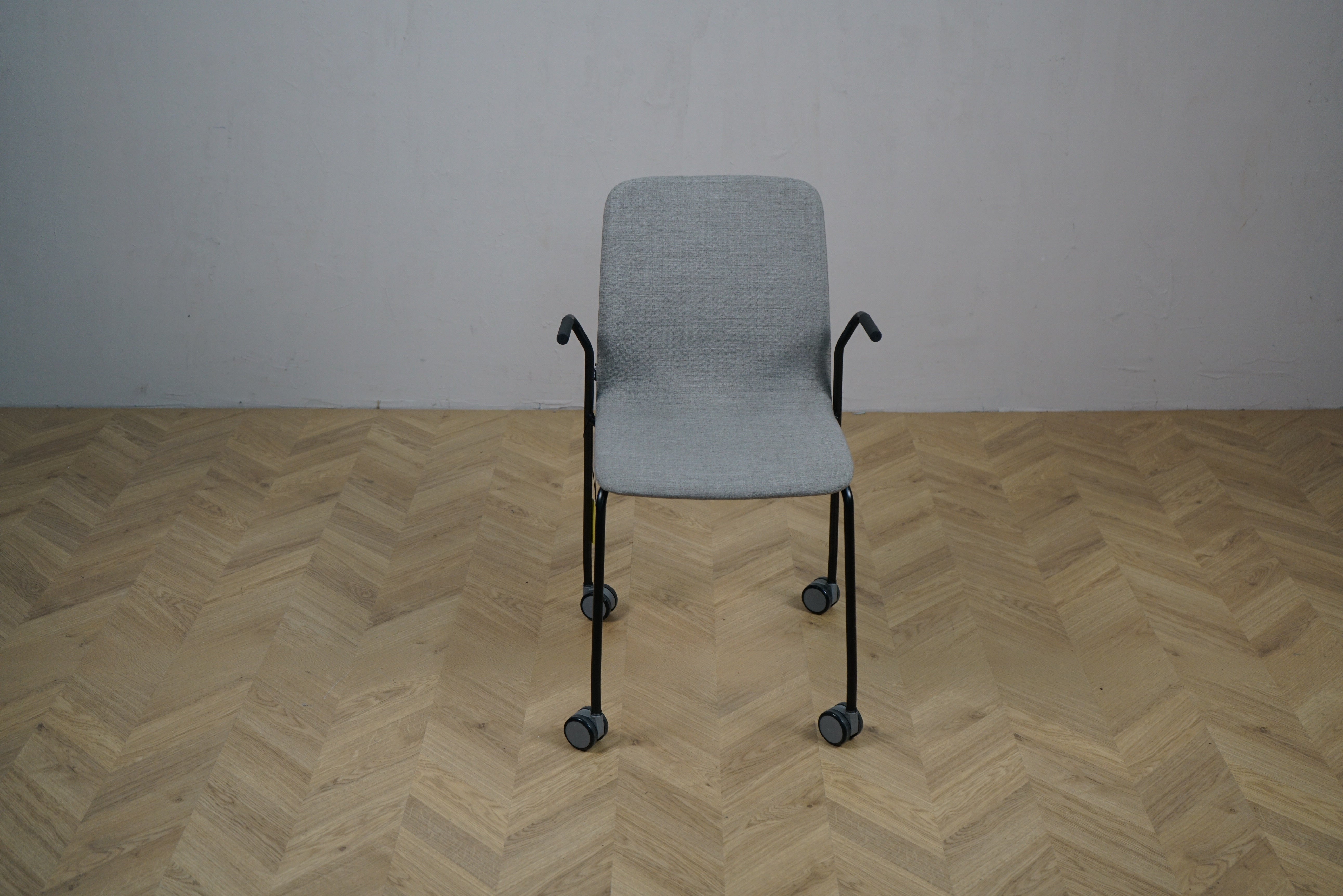 Kinnarps Nilo grå arbejdsstol set forfra – stabelbar stol med armlæn og hjul